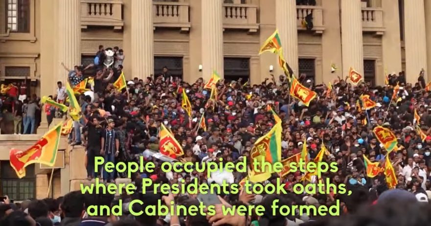 wide image of crowds with Sri Lankan flags on the steps of the country's presidential palace, on July 9, 2022